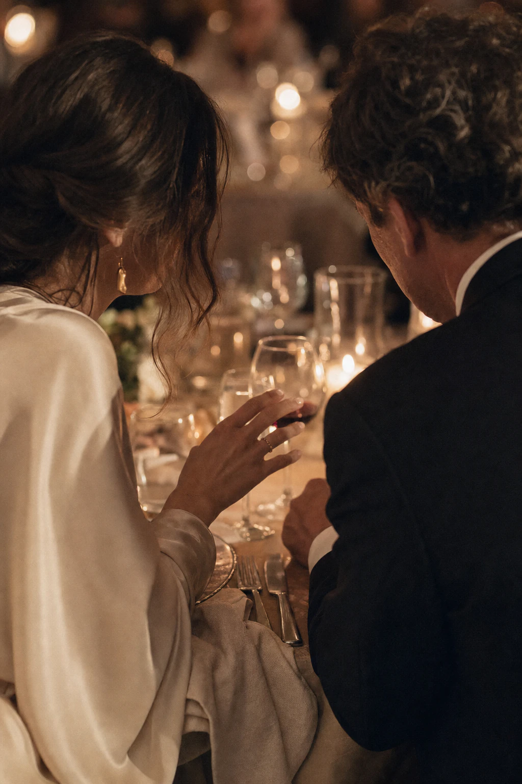 Couple sharing an intimate moment at a candlelit dinner table