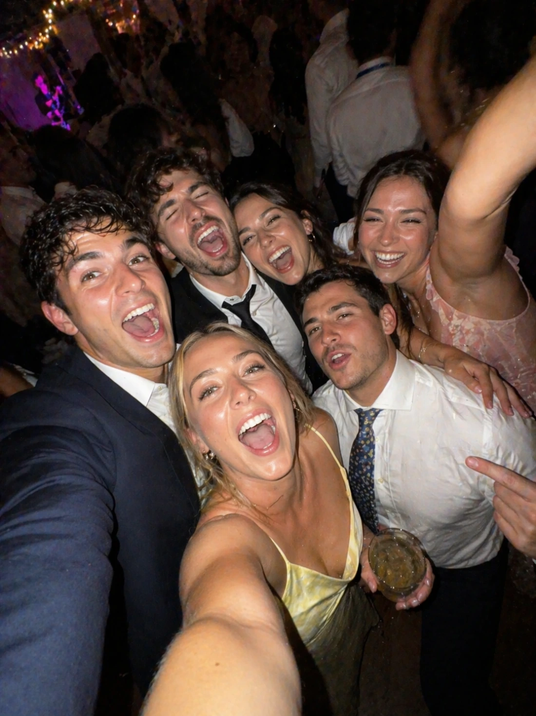 Friends taking a dance floor selfie at a wedding