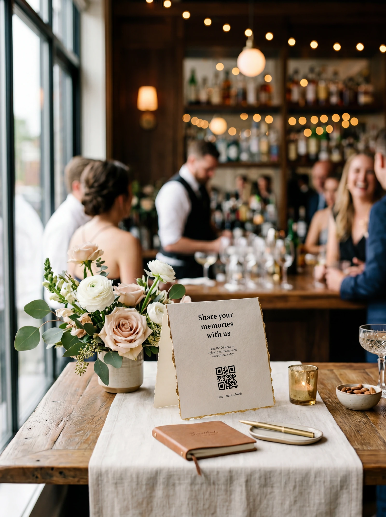 Gold-edged QR tent card beside a guest book and lit candle near a bar
